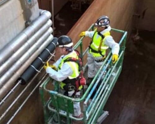 Workers Installing Dragon Jacket Insulation on Pipe Elbow