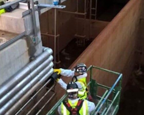 Workers Installing Dragon Jacket Insulation on Pipe Elbow