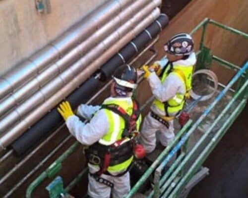 Workers Installing Dragon Jacket Insulation on Pipe Elbow