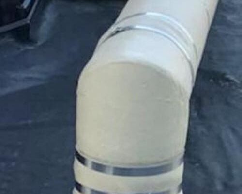 dragon jacket insulation installed in north dakota oilfield, focus on tan sharp 90° elbow